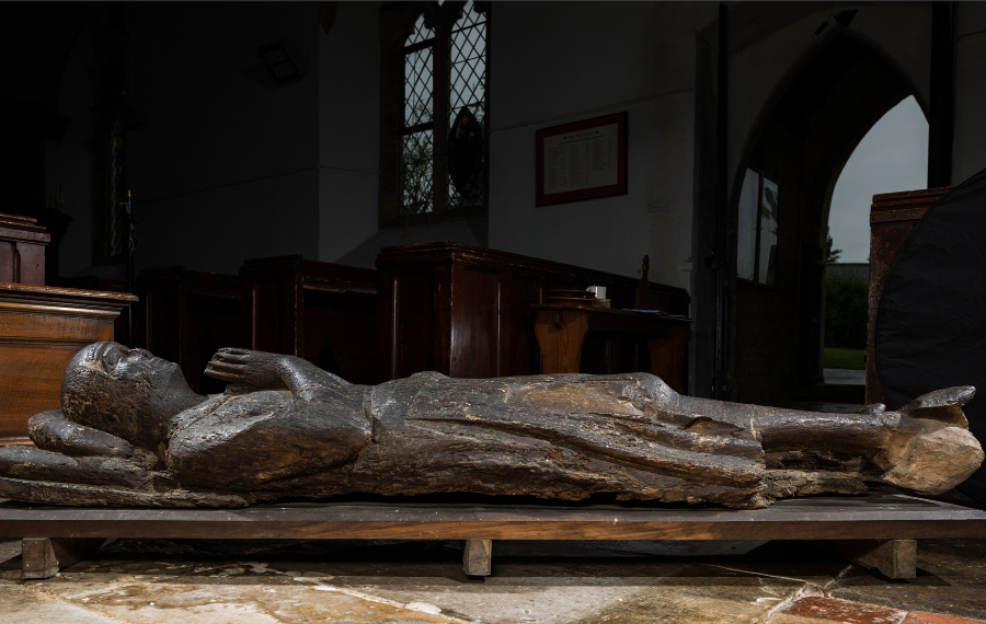 Knight Effigy (Credit: James Rudd) Restored old dark, wooden effigy of knight lying down with hands in pray in the middle of a old church.