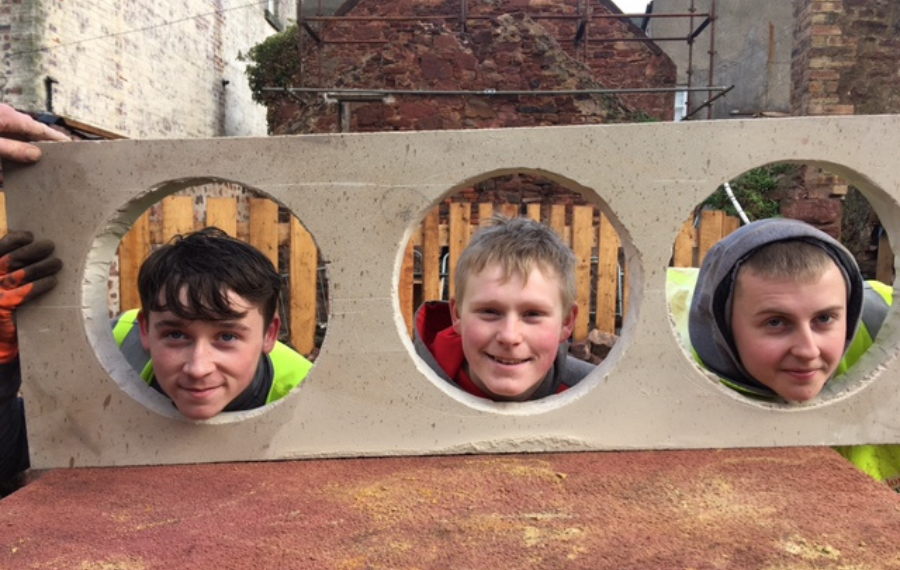 The Ridge SCIO Three white teenage boys smile through three circles made into a white stone slab.
