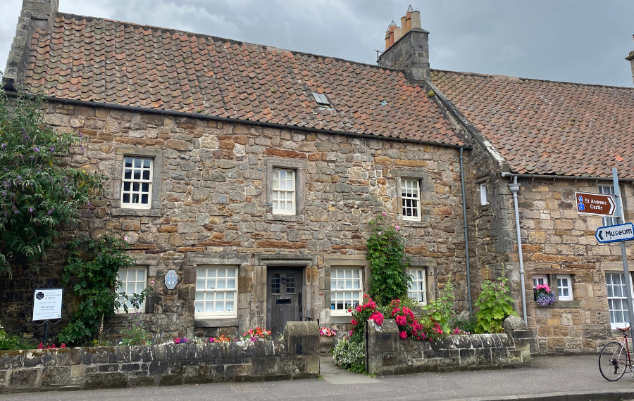 St Andrew Heritage Museum (c) St Andrews Preservation Trust There is an old stone, two storey building, the museum, with flowers and plants outside. The windows are sash style, painted white and the door is an old grey wooden door.