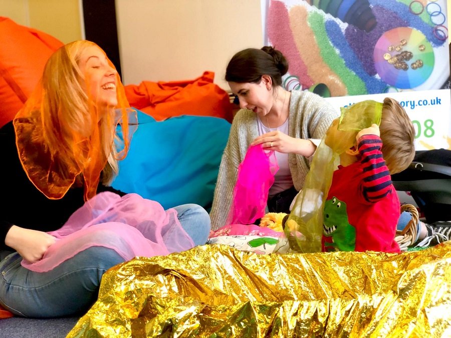 Credit – The Parent Rooms Young mothers play with their children with various different fabrics.