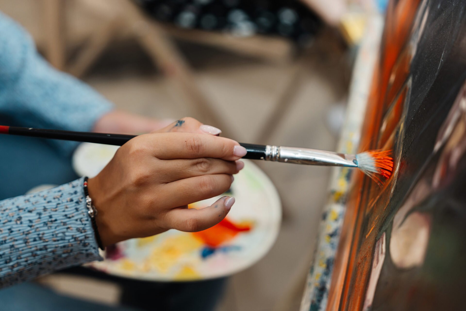 Creative artist engaged in painting with vibrant colours colors in a studio setting Close up of artist's hands, painting with vivid colours.