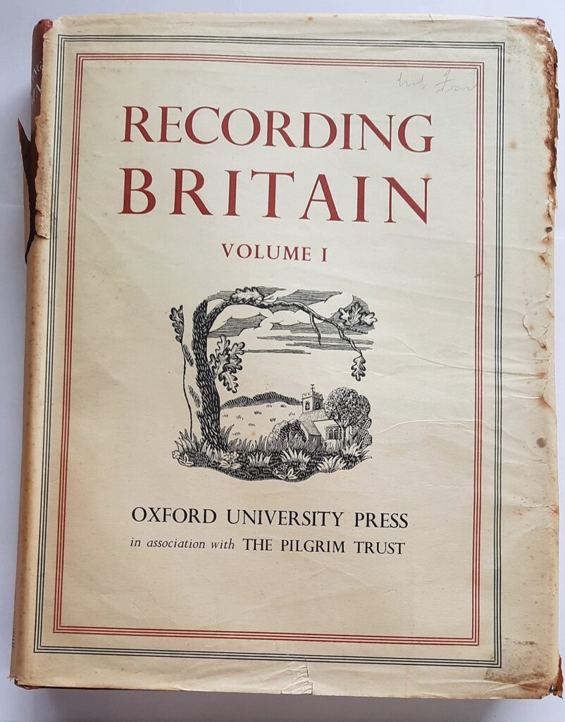 White book cover with red writing saying 'Recording Britain, Volume I. Oxford University Press in association with The Pilgrim Trust'.
